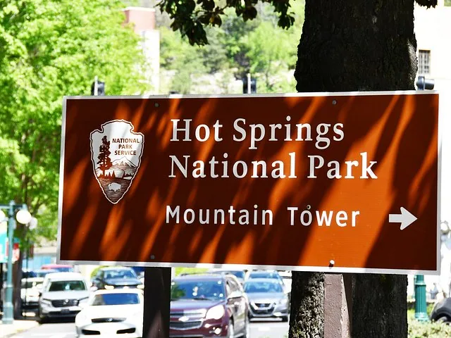 Un panneau marron indiquant 'Hot Springs National Park' et pointant vers 'Mountain Tower'.